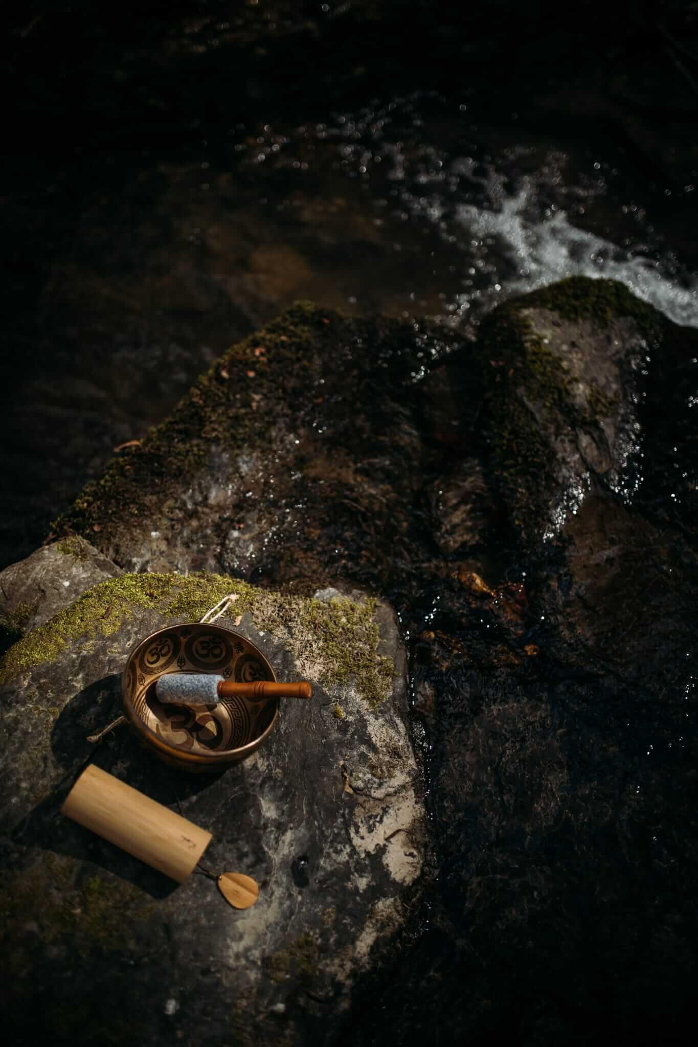 Klangschale auf einem Stein am Wasser